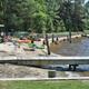Beach and small dock area with people and waterfront grassy beach — illustrates the campground’s swimming/beach area referenced on the site (Slide-7-Beach).