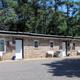 Exterior of the motel building (row of rooms) showing guest entrances and parking — useful to represent the motel accommodation on the property (from the site).