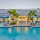 Bonita Terra pool at dusk with clubhouse, outdoor bar seating, and depth markers