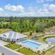 Aerial perspective focused on clubhouse, pool and adjacent pond with surrounding landscaping — indicated on the site as a pool/clubhouse aerial (social image on main page).