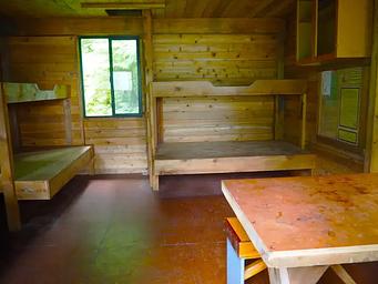 Frosty Bay Cabin, wooden interior of cabin with four bunks and a table