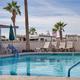 Outdoor swimming pool with lounge chairs and palm trees; clearly shows resort amenity on-site (photo on the property page).