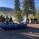 Launch/riverfront area with rafts and anglers gathering on a gravel bar — represents the campground’s river access and rafting/guide operations described on the property pages.