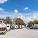 Panoramic view of pull-through RV sites with trees and sky — clearly depicts campsite density and environment used on the site’s social/feature image.