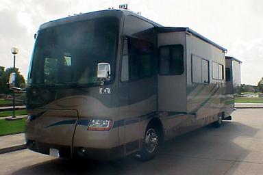 Close-angle photo of a brown motorhome on a paved lot with landscaping in background; on the homepage and depicts the company’s rental vehicles and outdoor display area (page: Motorhome Rentals and Service Center).