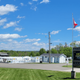 Wide shot of the pool area, adjacent buildings and RV parking with campground sign visible — useful for showing facilities and layout (appears in site header/gallery).