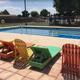 Outdoor swimming pool with colorful lounge chairs at USA RV Park in Gallup, New Mexico