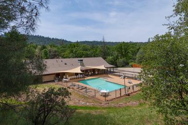 Resort swimming pool and clubhouse fenced area set within the property — clear facility shot useful for guests (homepage/gallery).