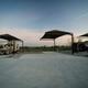 Wide view of multiple RV pads with overhead shade structures and concrete pads — shows the spacious, extra-long RV sites advertised on the Rates page (page: /rates).