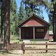 The front of a cabin with a wooden fence.