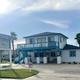 Front/entrance view of the office/building and sign with palms and property grounds visible — useful for identifying the resort entrance and office location (from homepage background).