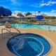 Clear pool and spa photo on the resort banner—shows on-site heated pool and hot tub with fencing and umbrellas, consistent with property amenities on the Lakewood RV Resort page.