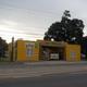 Street-facing photo of a distinctive yellow building (likely park office/entrance) on the property's site — helpful to identify the reception/road frontage and visitor entrance.