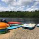 Shoreline image showing paddleboats, kayaks and a small beach area by a lake — represents waterfront recreation available at the campground (appears in site image gallery/assets).