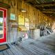 Porch/boardwalk of a rustic building on the property with decorative barrels and signage — conveys onsite amenities and style (gallery page).