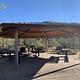 Large covered ramada with 3 picnic tables, benches, a grill and trashcans