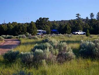 Truck, tent trailer and pop-up canopy in a campsite.