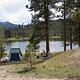 Tent, picnic table with mountains and lake in backgorund