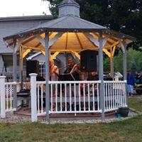 Gazebo with people/instruments in a lawn area — shows a communal gathering space on the property; from the site's About Us page (page title: ABOUT US | Mysite).