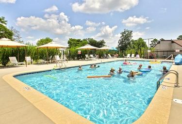 Outdoor swimming pool with lounge chairs and umbrellas — clearly depicts the campground's pool amenity and recreational setting (used on the property page).