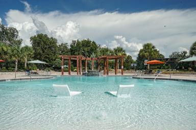 Wide pool view with lounge seating, pergola and landscaping — highlights the on-site swimming facilities and guest amenities (used on the homepage/stay pages).