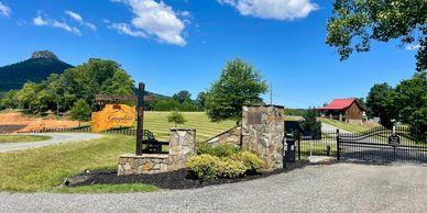 Entrance/gate photo with the Greystone sign, landscaping and park buildings visible — good for identifying property access and curb appeal (Amenities page).