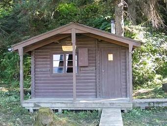 Sergief Island Cabin exterior brown wood cabin with greenery surrounding it