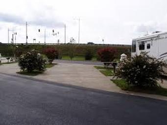 Close view of an individual RV pad with concrete pad, hookups, picnic table and landscaping; clearly shows campsite amenities and layout useful for guests evaluating sites.