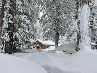 Heavy equipment plow through several feet of snow