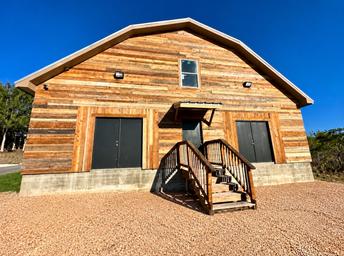 Exterior of a large wood-clad building (commercial/warehouse space) on the property shown on the 'Commercial Space' page (https://www.thebuzzrv.com/commercial-space) — useful to show available on-site facilities and structures.