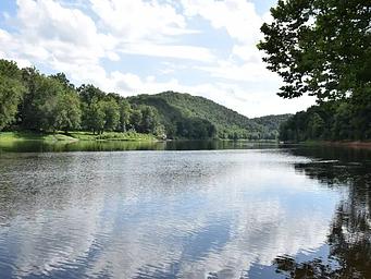 The Potomac River reflects a blue sky and fluffy clouds at McCoys Ferry