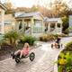 Depicts small cabin units and paved paths with guests (kids riding carts) — a clear photo of the campground's cabin area; sourced from the property 'waystostayphotos' gallery on the KOA campsite page.