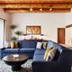 Hacienda 1 bedroom living room with blue couch and wood beam ceilings