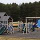 Wide panoramic image of the playground and adjacent aqua/park features — useful overview of family amenities on the property (page context: new playground).