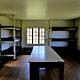interior view of cabin showing stacked bunks, table, and lockers.