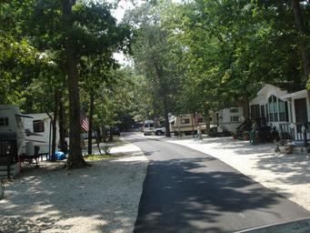 Another view of an RV row and paved roadway with sites on both sides — useful alternate perspective of RV accommodations and site spacing.