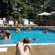 Active pool scene with swimmers and deck chairs — demonstrates recreational facilities available at the campground.