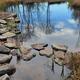 Small landscaped pond with stone edging and reflections — highlights on-site water feature and natural landscaping shown on the Welcome page.