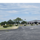Wide, high-resolution ground view of the property entrance/lot showing the RV Park building, parking area and landscaping — useful as an overall on-site photo for the campground gallery. Matches page hero/social image context.