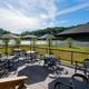 Raised deck with tables and umbrellas overlooking the river — shows campground facility/amenity with river views (page context: campground/homepage imagery).