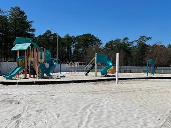 Playground area set in sand with play structures visible — useful for showing on-site family amenities and beach-front recreation (from the property gallery).