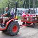Tractor pulling a wagon with children and RVs/sites visible in background — useful view of campground atmosphere, on-site events and RV/campsite layout (source: Facilities page).