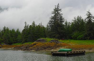 Berg Bay with a canoe on a float with cabin in the background and trees