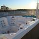 Close-up of a hot tub on the rooftop/deck area with the park and horizon in the background — highlights a notable amenity.