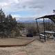A tent pad and covered picnic table with a background of Sleeping Ute mountain range's snow-covered peaks.