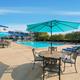 Clear daytime photograph of the resort’s swimming pool, deck seating and surrounding amenity area — matches the amenities listed on the property page.
