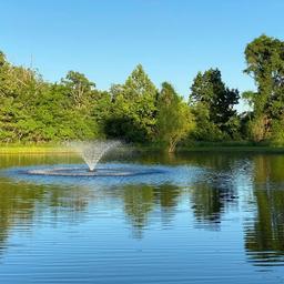 Vertical pond view with fountain and reflected trees — another on-site pond image from the gallery that provides an alternate composition of the campground’s water feature and surroundings.