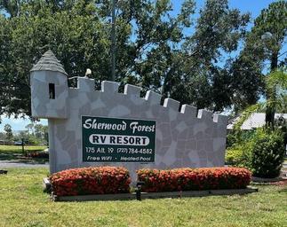 Photograph of the Sherwood Forest RV Resort stone entrance sign with landscaping — good identifying exterior shot, sourced from the site Home page.