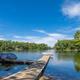 Clear waterfront view of a dock and pontoon on a wooded lake — shows Panther Lake itself (used as page background on the resort homepage), supporting that this is on-site scenery.