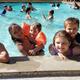 Clear photo of the campground swimming pool with guests enjoying the water — shows on-site amenity and matches hero image used on the campground page.